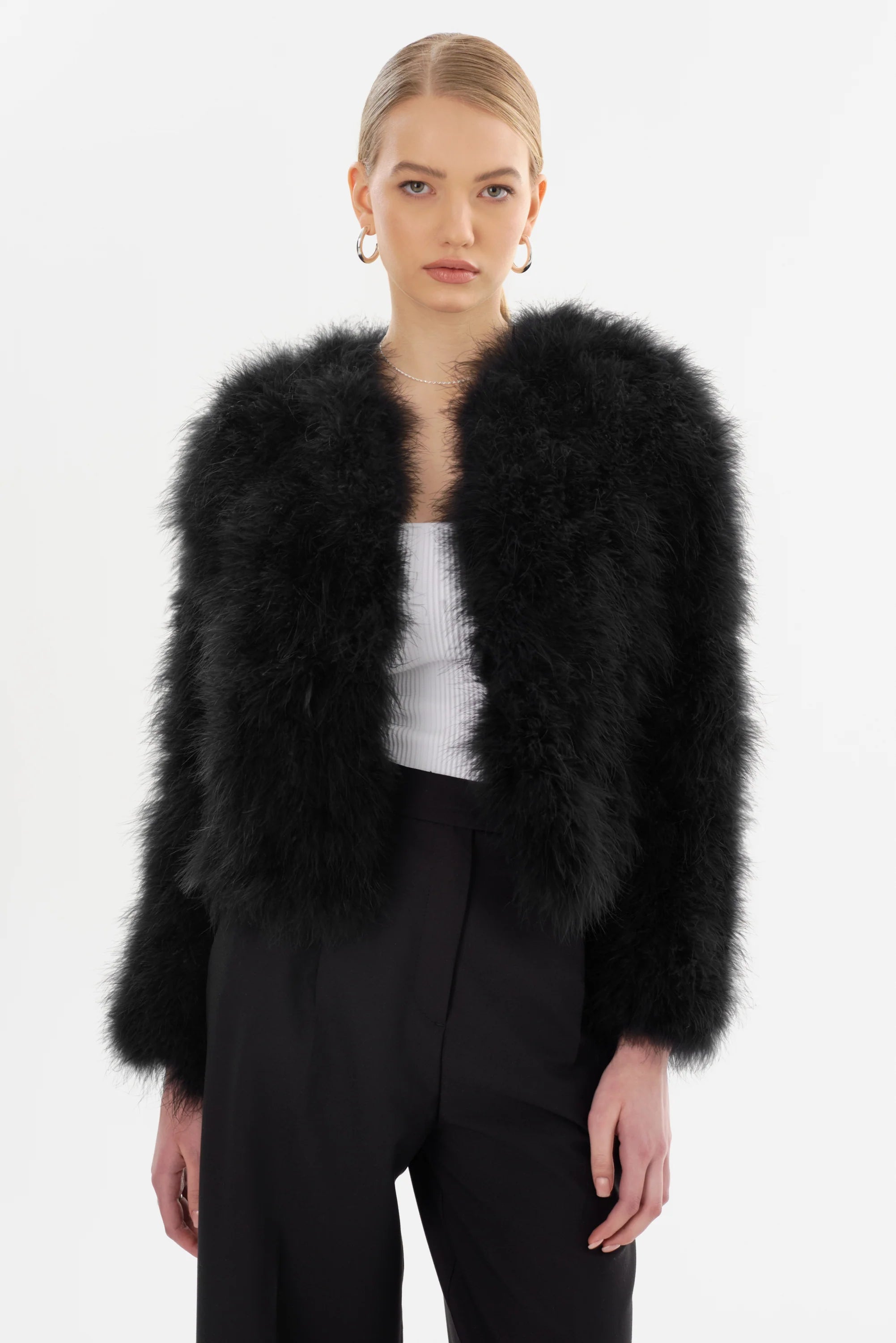 Woman wearing a black feathered jacket on a white background