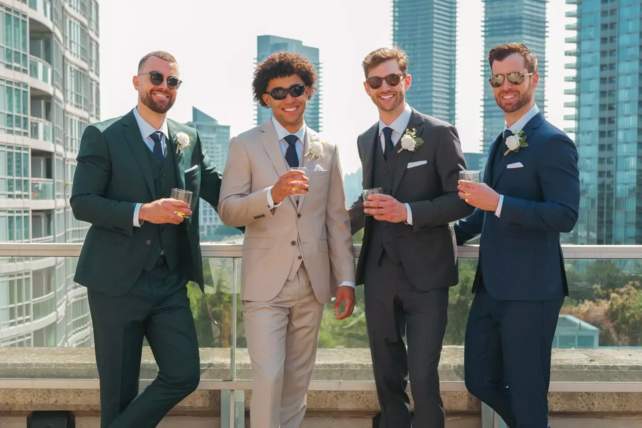 Four men in suits standing together with city skyline in the background